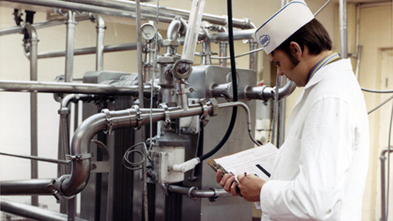Ecolab technician from the 1970s reviewing equipment documentation