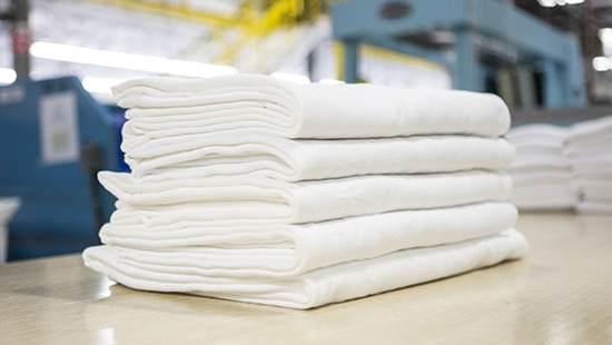 Stack of white towels in a commercial laundry facility