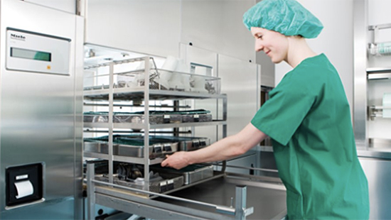 Ecolab instrument reprocessing room with a disinfectant specialist organizing trays in a washing station.