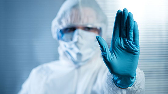 Cleanroom technician holding up a gloved hand