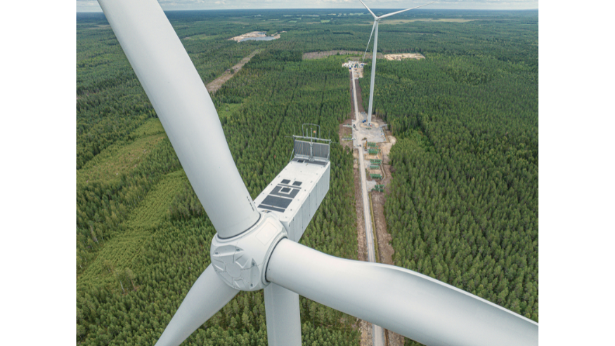 Aerial view of part of a windmill with natural landscape in the background