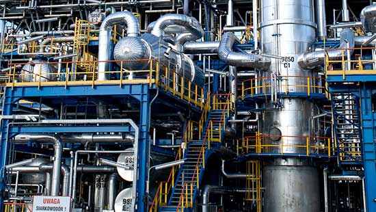 Massive multi-floor cylinders with pipes flowing throughout a sour water stripper facility.