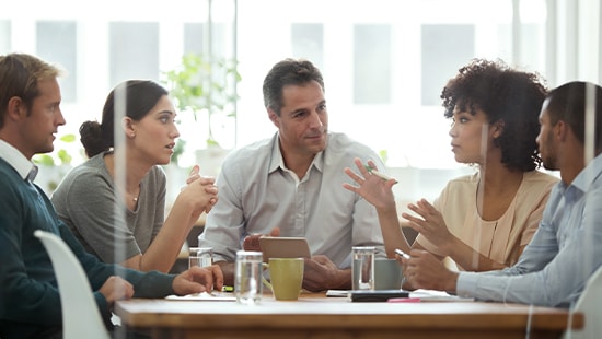 Group of people at table in conference room talking.