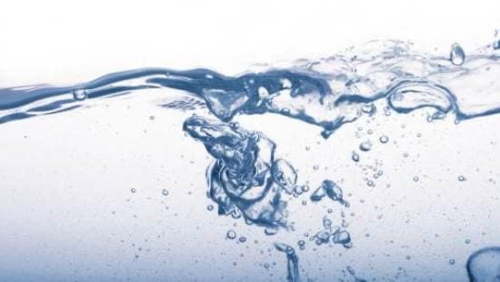 Close up of water swirling and bubbling on a white background.