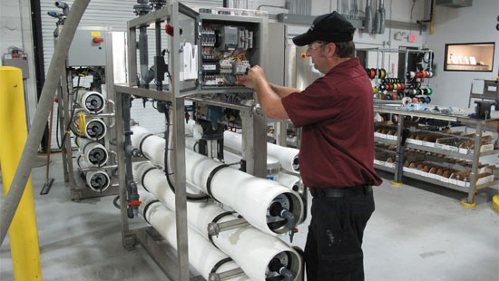 Distributor working on wire panel of large industrial machine.