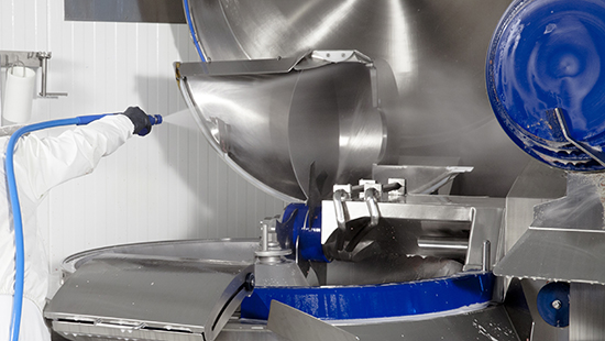 Worker with Hose Cleaning Personal Care Manufacturing Equipment