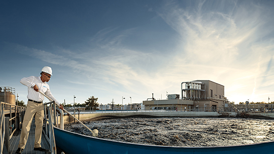 Worker treating wastewater at manufacturing facility