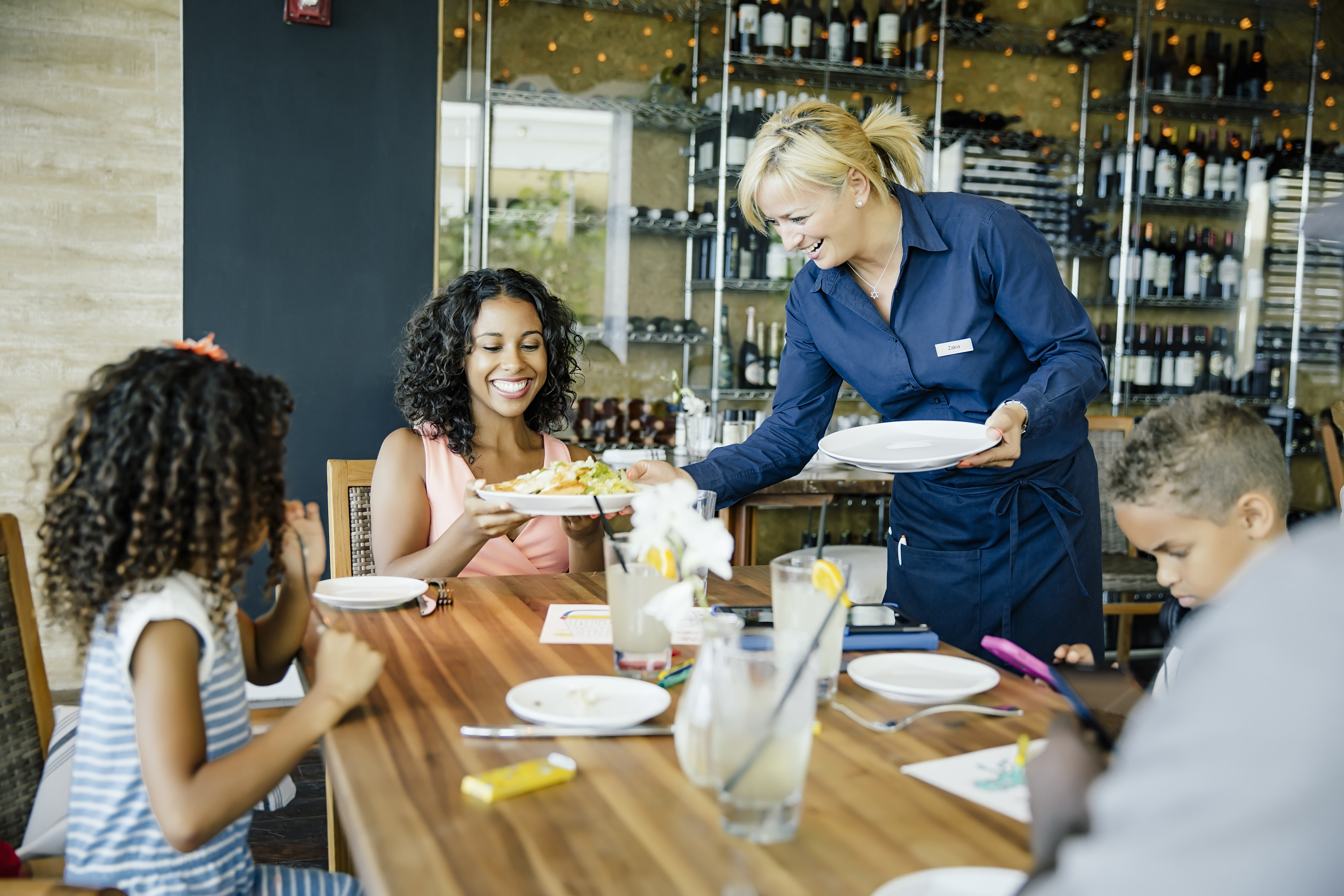 Guests being served at restaurant table.