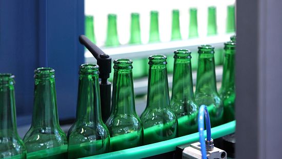 green glass bottles on conveyor belt