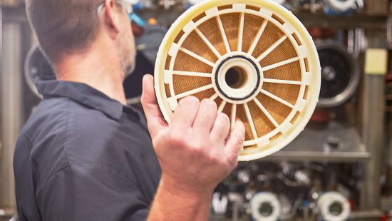 Distributor working on wire panel of large industrial machine.