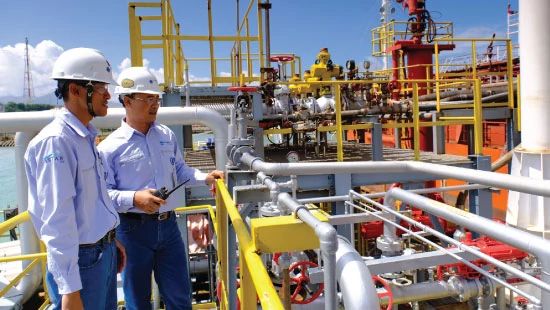 Two employees of Chandra Asri, an Ecolab partner, outside working at their petrochemical facility